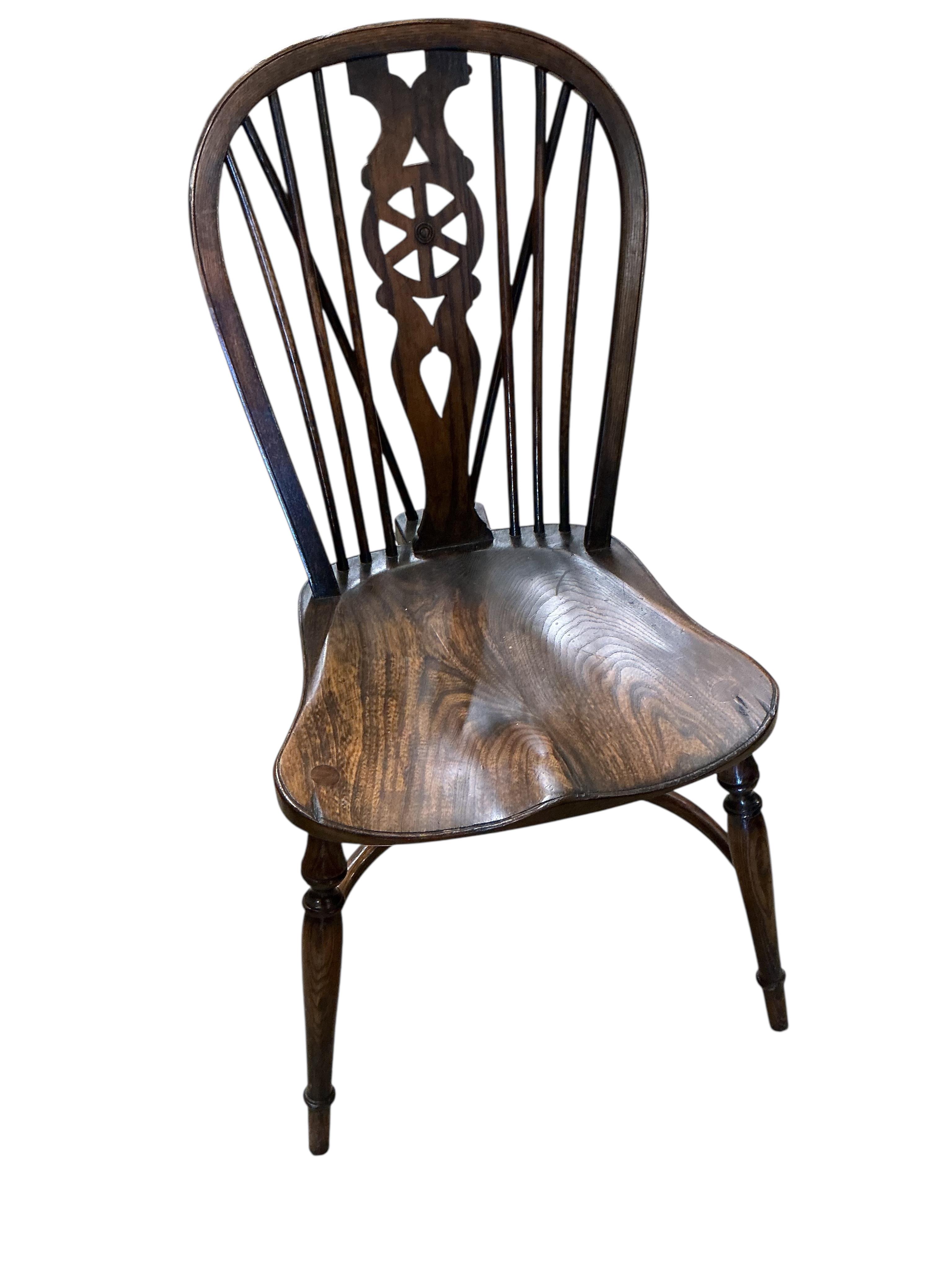 A set of ten reproduction Windsor elm and beech dining chairs with pierced splats and crinoline stretchers, two with arms